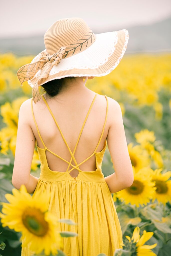 „Tagantjärele tarkus ei ole tarkus, vaid kogemus“ rear, girl, back, girl's back, yellow dress, sun hat, dress, sunflowers, sunflower field, phone wallpaper, young woman, female model, aesthetic wallpaper, iphone wallpaper