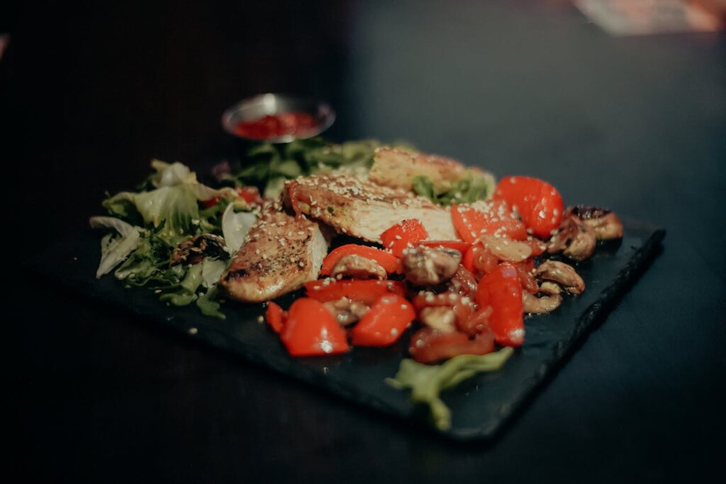 Miks „teadmisest“ ei piisa – ja mida ma õppisin erivajadustega inimeste toetamisest ja toidust Savor a savory dish of grilled chicken with vibrant peppers, mushrooms, and greens.