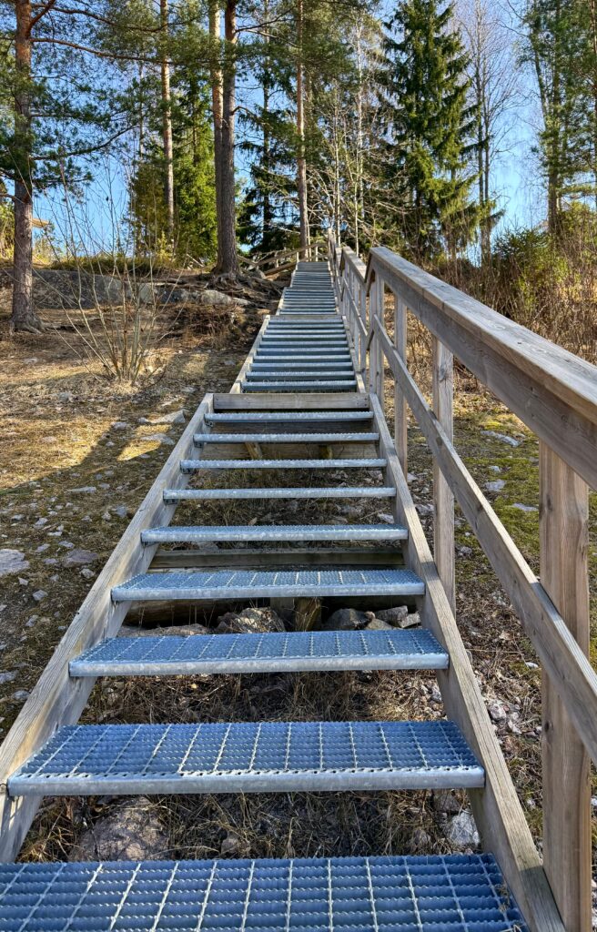 Ma tunnen kaasa, aga ma ei kanna enam kogu maailma oma õlgadel. Long wooden staircase leading through Nuuksio forest in Finland.