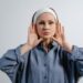 Kui vaikus õpetab kuulama – mõtteid erivajadusest, empaatiast ja kliendikesksusest Portrait of a woman in a blue shirt with hands on her face, wearing a headband, on a white background.