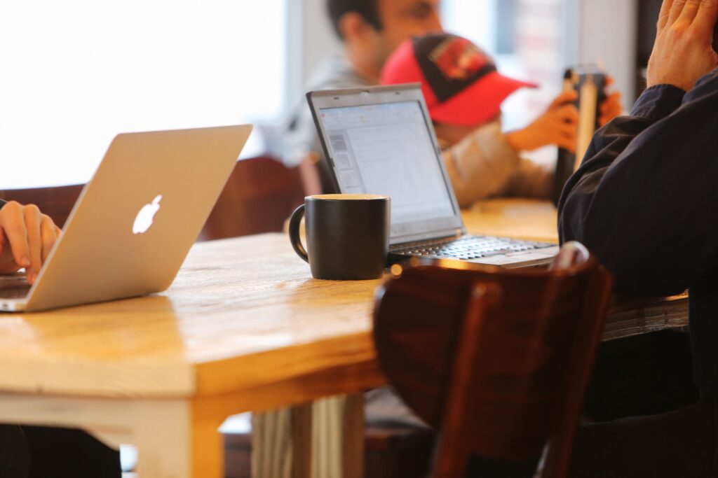 Kui “tõde” ei põhine konkreetsetel faktidel – kus jookseb piir hinnangu ja oletuse vahel? Koos lisatud kirjavahetustega. Group working in a cozy cafe with laptops and coffee mugs on a shared table.