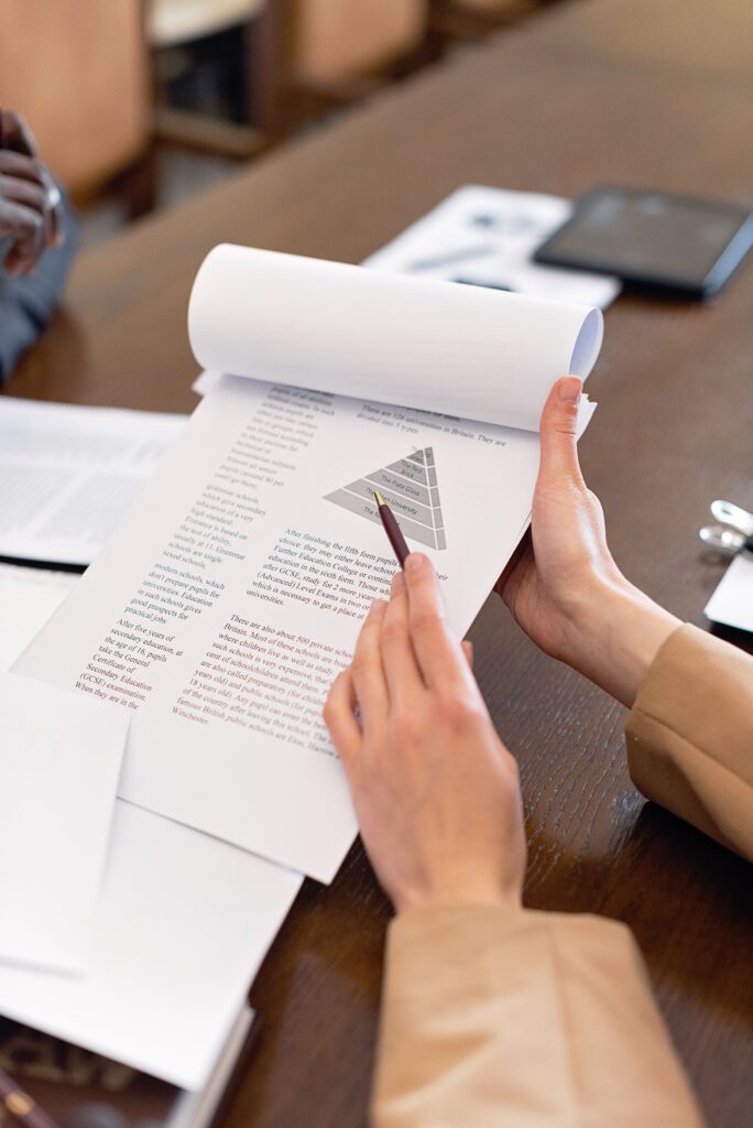 Tervislikud harjumused, heaolu ja personaalsed tegevusplaanid Close-up of hands holding a document with a pen pointing at a chart, perfect for business presentations.