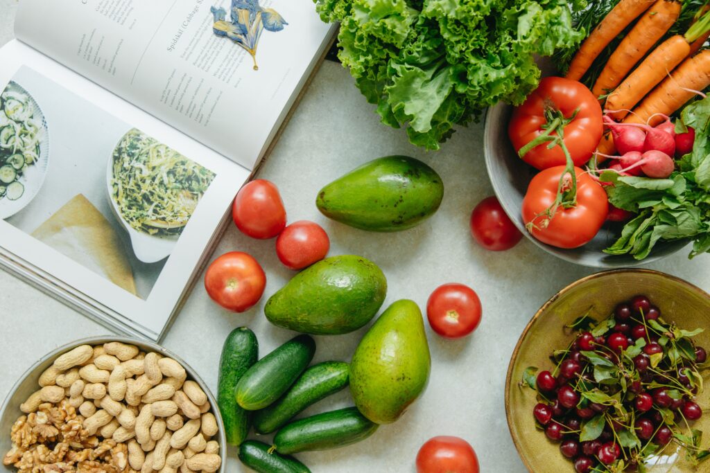 Muutus ei alga kaalul ega lõpe ühe otsusega An appetizing display of fresh fruits and vegetables with a cookbook, perfect for healthy recipes.