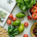 Kuidas teha tervislikumaid toitumisvalikuid? An appetizing display of fresh fruits and vegetables with a cookbook, perfect for healthy recipes.