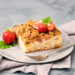 A slice of homemade cake topped with fresh strawberries and mint, perfect for a healthy dessert.