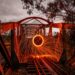 Captivating long exposure shot of light painting with sparks on an old railway bridge at night.