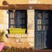 Rustic cottage entrance with blue door and windows in Mortagne-au-Perche, France.