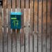 A green mailbox numbered 17 on a rustic wooden fence, creating a vintage outdoor feel.