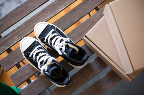Stylish high top sneakers on a rustic wooden bench with cardboard boxes. Perfect for fashion shoots.