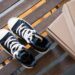 Stylish high top sneakers on a rustic wooden bench with cardboard boxes. Perfect for fashion shoots.