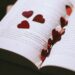 An open book adorned with red heart-shaped confetti, perfect for Valentine's or romantic themes.